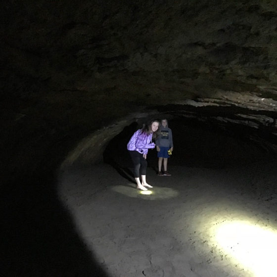 Kids Ducking Under the Low Ceiling Inside Newberry Lava River Cave