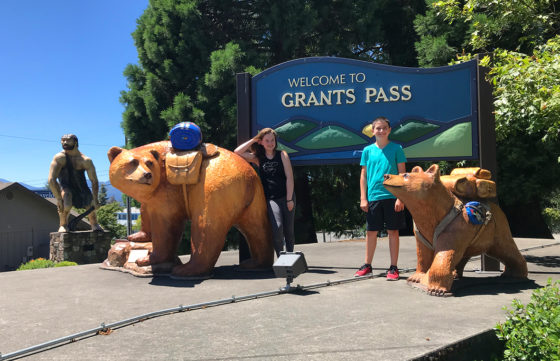 Natalie and Carter Bourn with the Grants Pass Bear and Caveman Statues