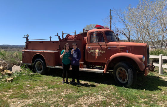 Natalie and Carter Standing In Front of A Vintage Fire Truck