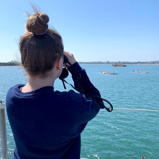 Natalie using binoculars to view sea lions